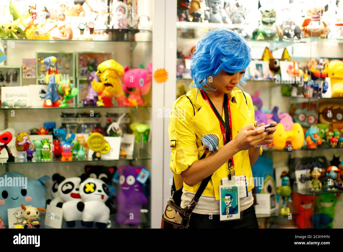 Un asistente vestido con textos de vestuario en un teléfono móvil en una tienda de juguetes en el piso de la convención Comic con durante el evento de cultura pop en San Diego, California 22 de julio de 2011. REUTERS/Mike Blake (ESTADOS UNIDOS - Tags: SOCIEDAD DEL ENTRETENIMIENTO) Foto de stock
