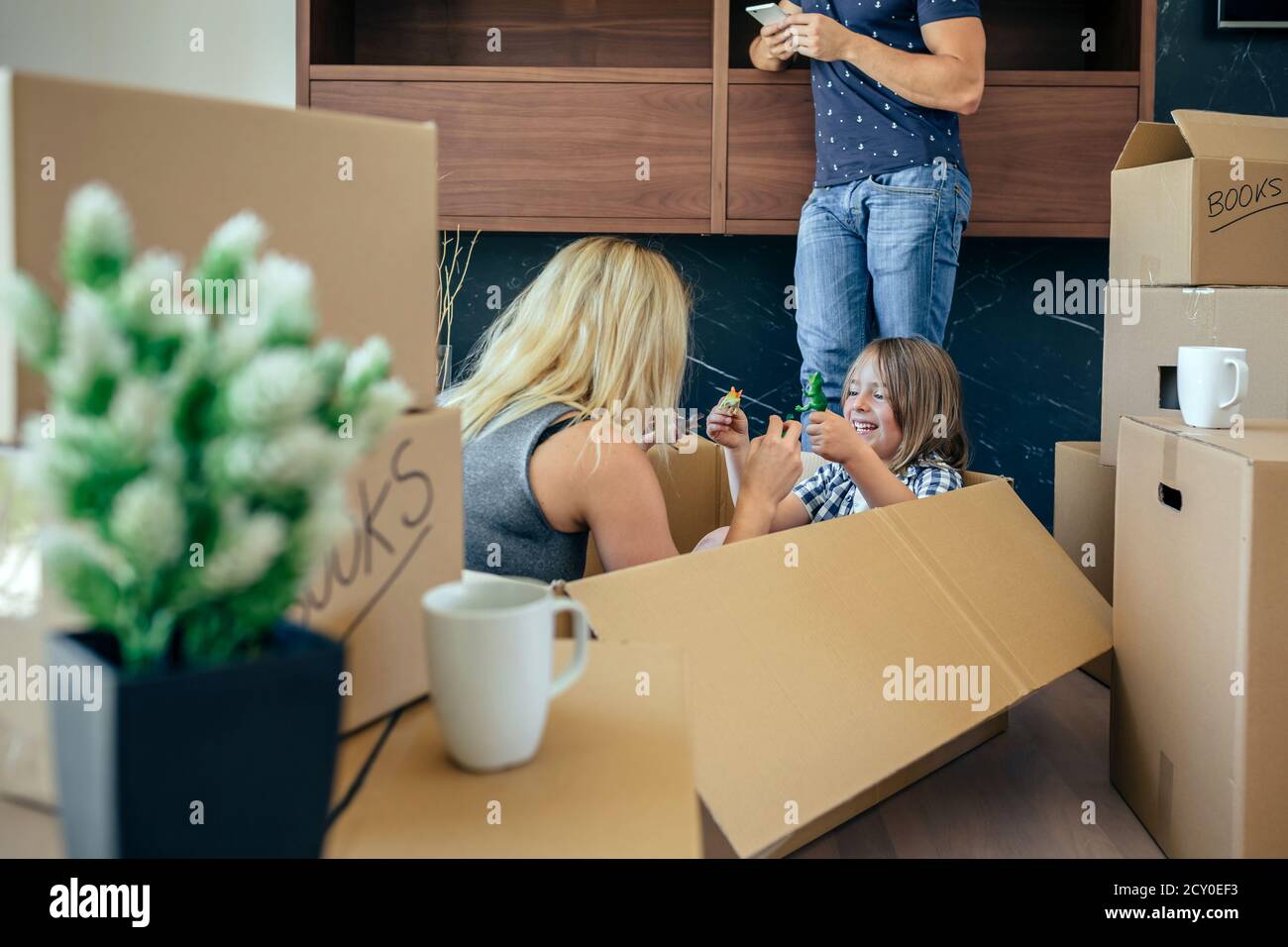 Madre e hijo jugando mientras padre mira el móvil Foto de stock