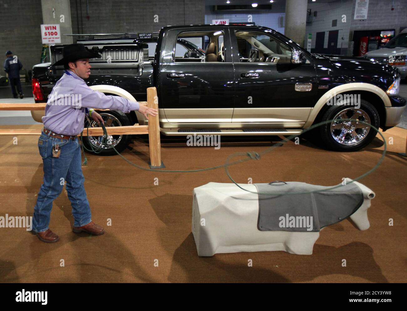 A cowboy practices his roping next to the 2011 Dodge Ram 1500 Laramie  Longhorn at the New York International Auto Show in New York City, April  21, 2011. REUTERS/Mike Segar (UNITED STATES -
