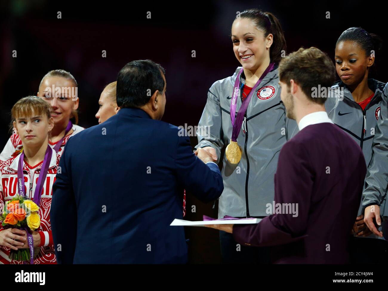 Team U S A Member Jordyn Wieber C Receives Her Gold Medal As She Is Watched By Team Mate Gabrielle Douglas R And Anastasia Grishina L Of Russia During The Women S Gymnastics Team Final Team U S A Member Jordyn Wieber C Receives Her Gold Medal As She Is Watched By Team Mate Gabrielle Douglas R And Anastasia Grishina L Of Russia During The Women S Gymnastics Team Final
