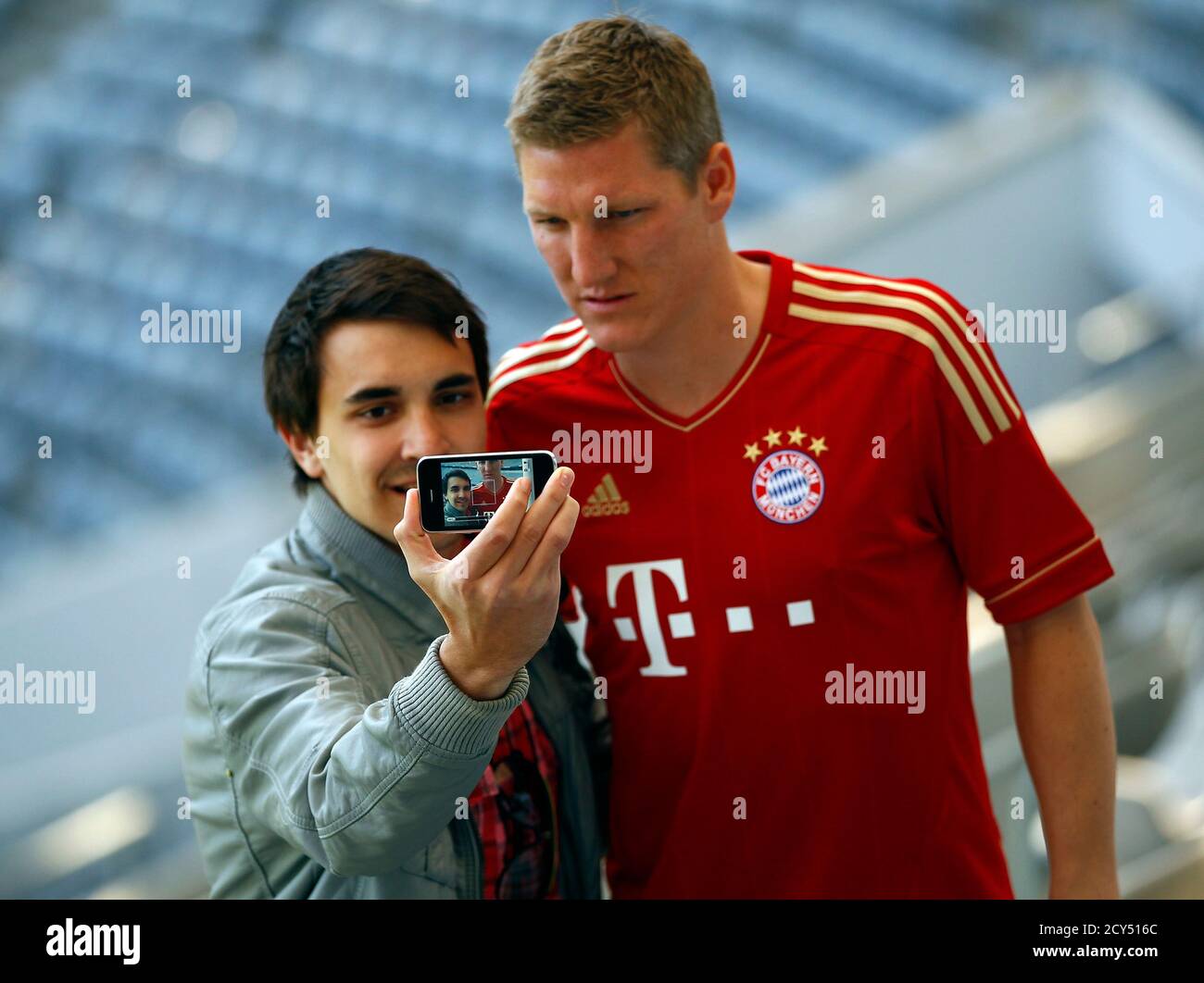 Bastian Schweinsteiger of FC Bayern Munich poses with a supporter after the  presentation of the club's new soccer jersey in Munich April 19, 2011. Bayern  Munich extended its contract with the German