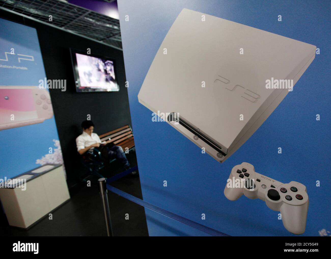 A man plays his Sony PlayStation portable console at a PlayStation wireless  spot in an electronic shop in Tokyo May 15, 2011. Sony said it had begun  restoration of its PlayStation Network