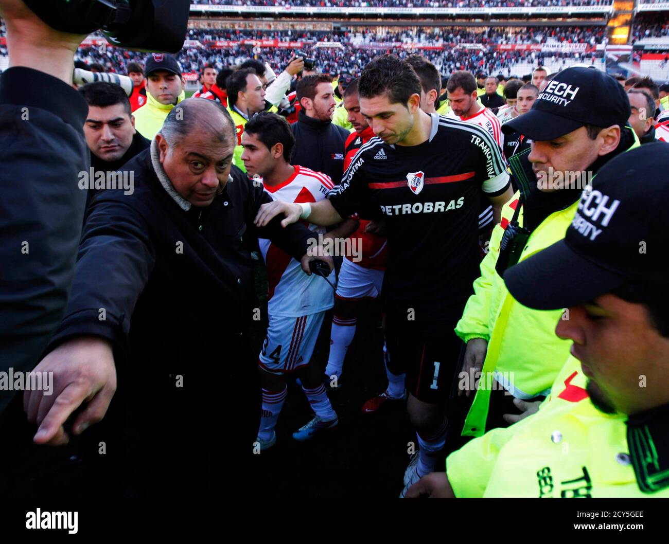 El capitán de River Plate, el portero Juan (C) y los compañeros de equipo abandonan el campo escoltado por oficiales de seguridad al final de su partido de