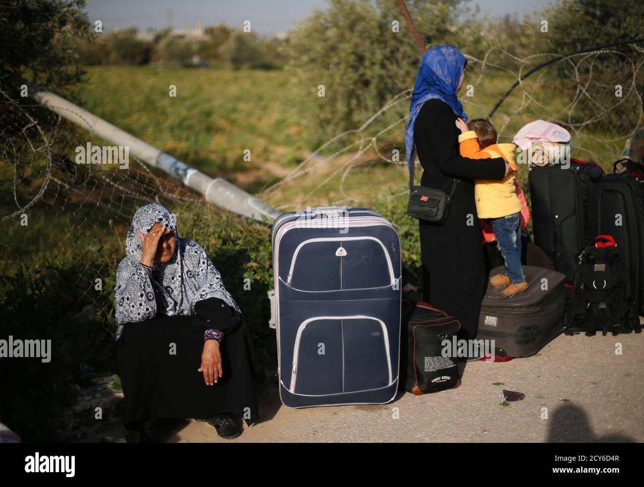 Una mujer palestina descansa junto a su maleta mientras espera un permiso  de viaje para cruzar a Egipto, en el cruce de Rafah entre Egipto y el sur  de la Franja de