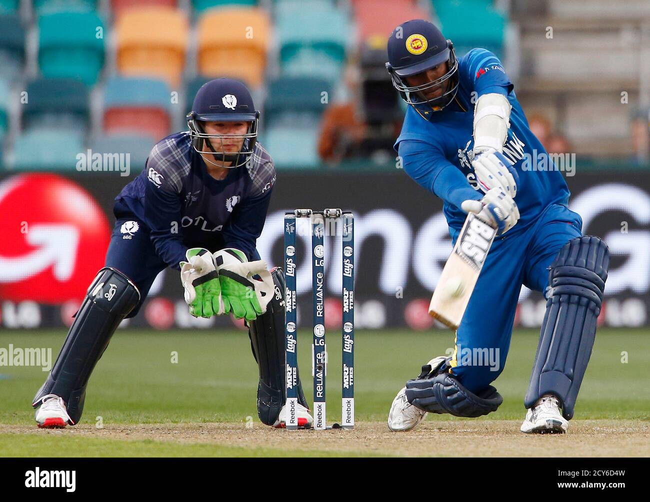 El capitán de Sri Lanka, Angelo golpea el balón durante seis carreras, mientras el maleterista de Escocia, Matt Cross (L), observa durante su partido de la Copa de Cricket en