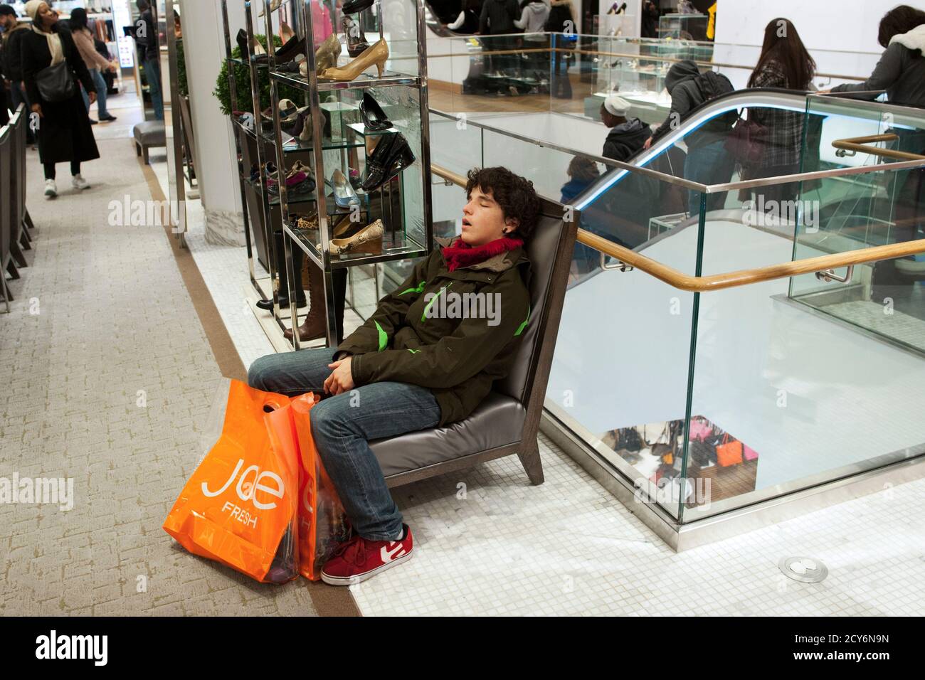 Un hombre con bolsas de compras duerme en Macy's en Nueva York, 24 de  diciembre de 2012. Los minoristas pasaron la Navidad con ofertas de última  hora en todo, desde televisores hasta