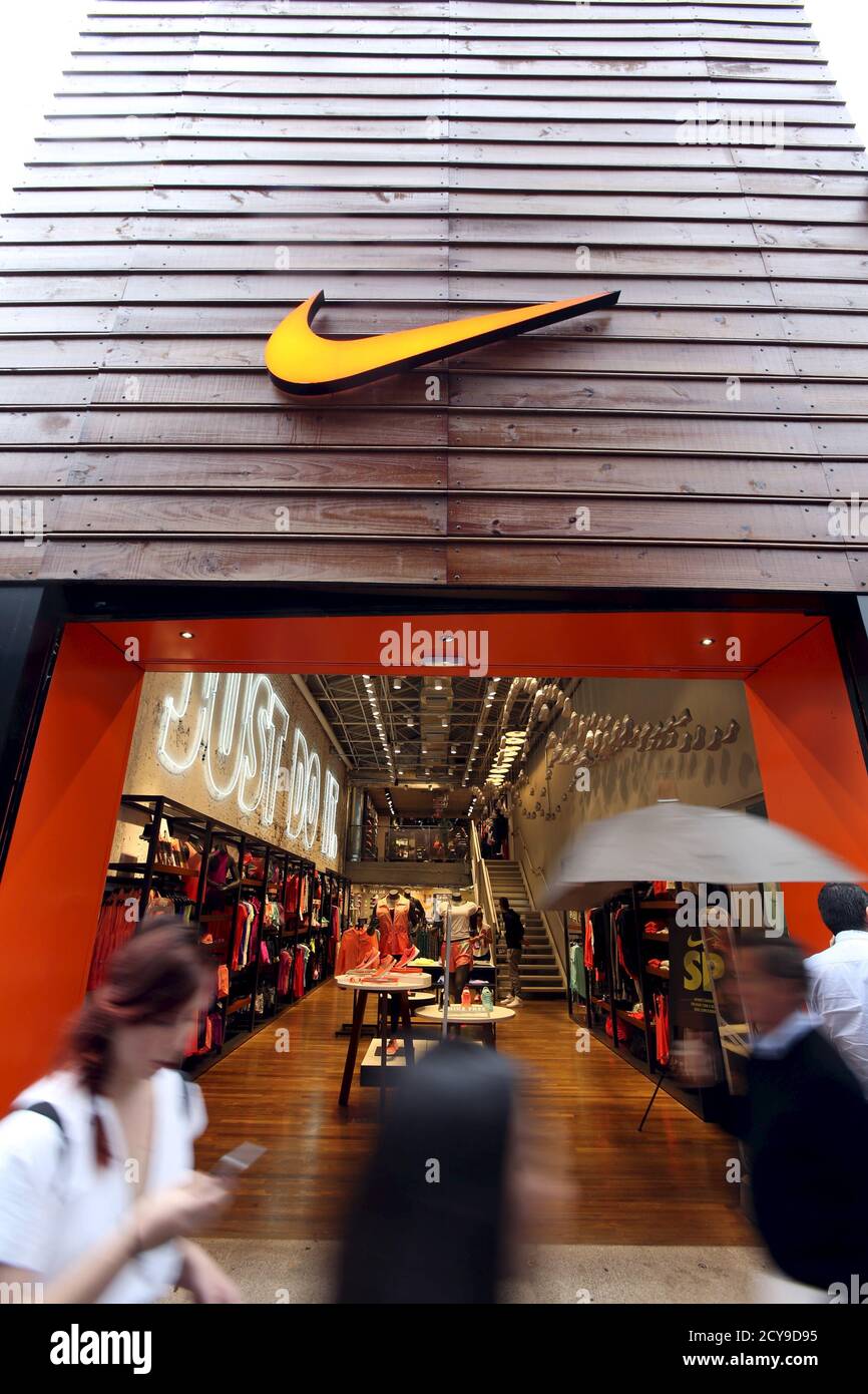 Los peatones pasan por una tienda Nike en Sao Paulo el 28 de mayo de 2015.  Nike, que no es un socio de la FIFA, pero está desafiando el dominio de  Adidas