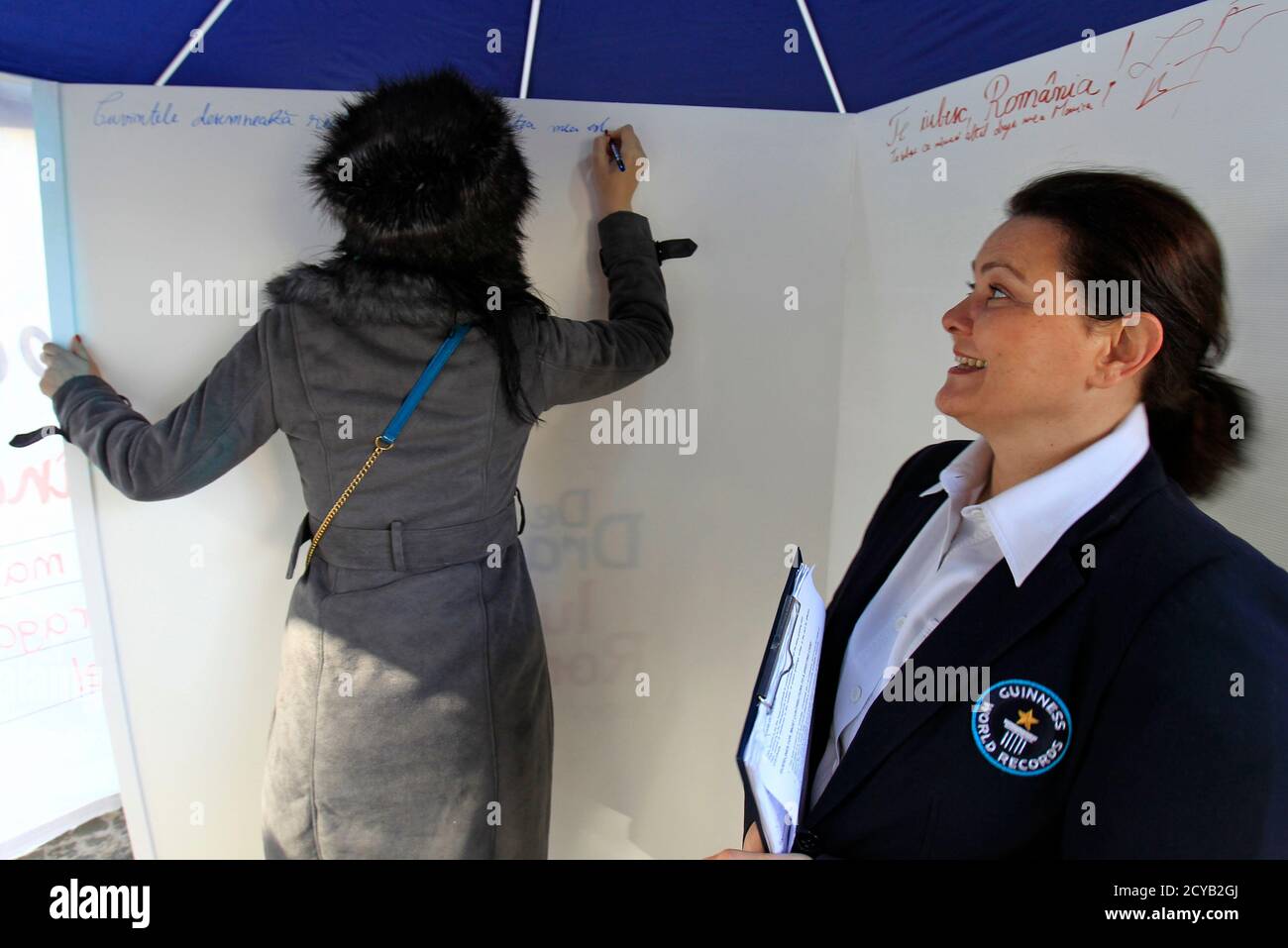 La adjudicadora de Guinness World Records Seyda Subasi-Gemici de Turquía  (R) reacciona mientras una persona escribe un mensaje de amor en un intento  de romper el récord Guinness del mundo por la