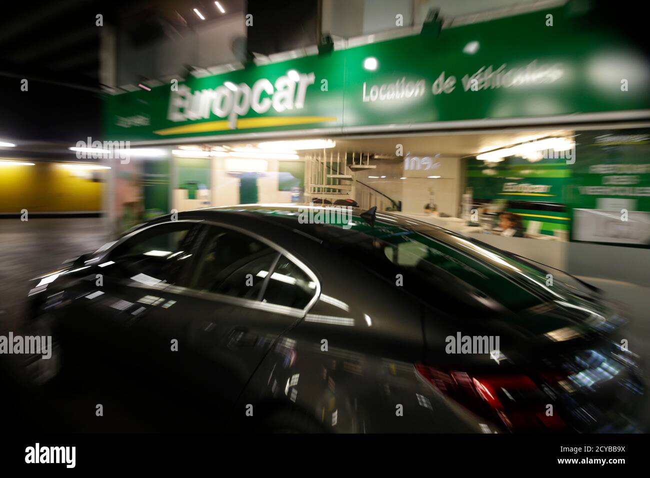 Un automóvil pasa por un punto de alquiler de coches Europcar en París, Francia, 15 de junio de 2015. Las ventas de acciones de la empresa francesa de alquiler de coches Europcar valorarán el grupo en hasta 2 mil millones de euros (2.2 mil millones de dólares) y los ingresos se utilizarán principalmente para reducir una carga de deuda que lo ha llevado a pérdidas en los últimos años. Europcar, que dice que es la empresa líder de alquiler de coches en Europa, espera recaudar al menos 854.5 millones de euros (957 millones de dólares) en la venta y se espera que las acciones comiencen a operar el 30 de junio. REUTERS/Philippe Wojazer Foto de stock