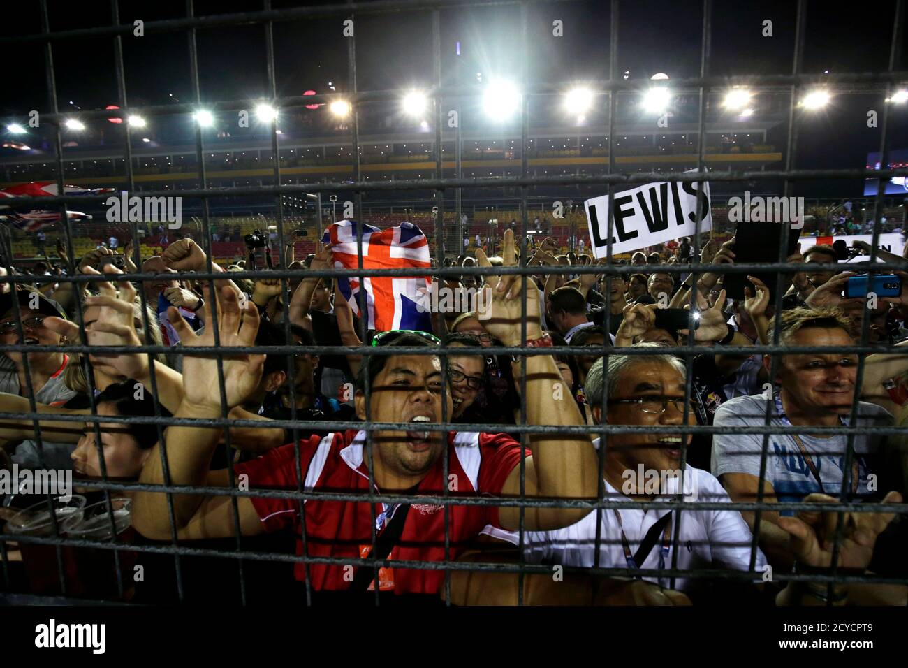 Fans cheer during the podium ceremony of the Singapore F1 Grand Prix at the Marina Bay street circuit in Singapore September 21, 2014. Lewis Hamilton stormed to an emphatic victory at the Singapore Grand Prix on Sunday to wrest the championship lead from Mercedes team mate Nico Rosberg after the German retired with steering wheel problems. REUTERS/Xavier Galiana (SINGAPORE - Tags: SPORT MOTORSPORT F1) Foto de stock