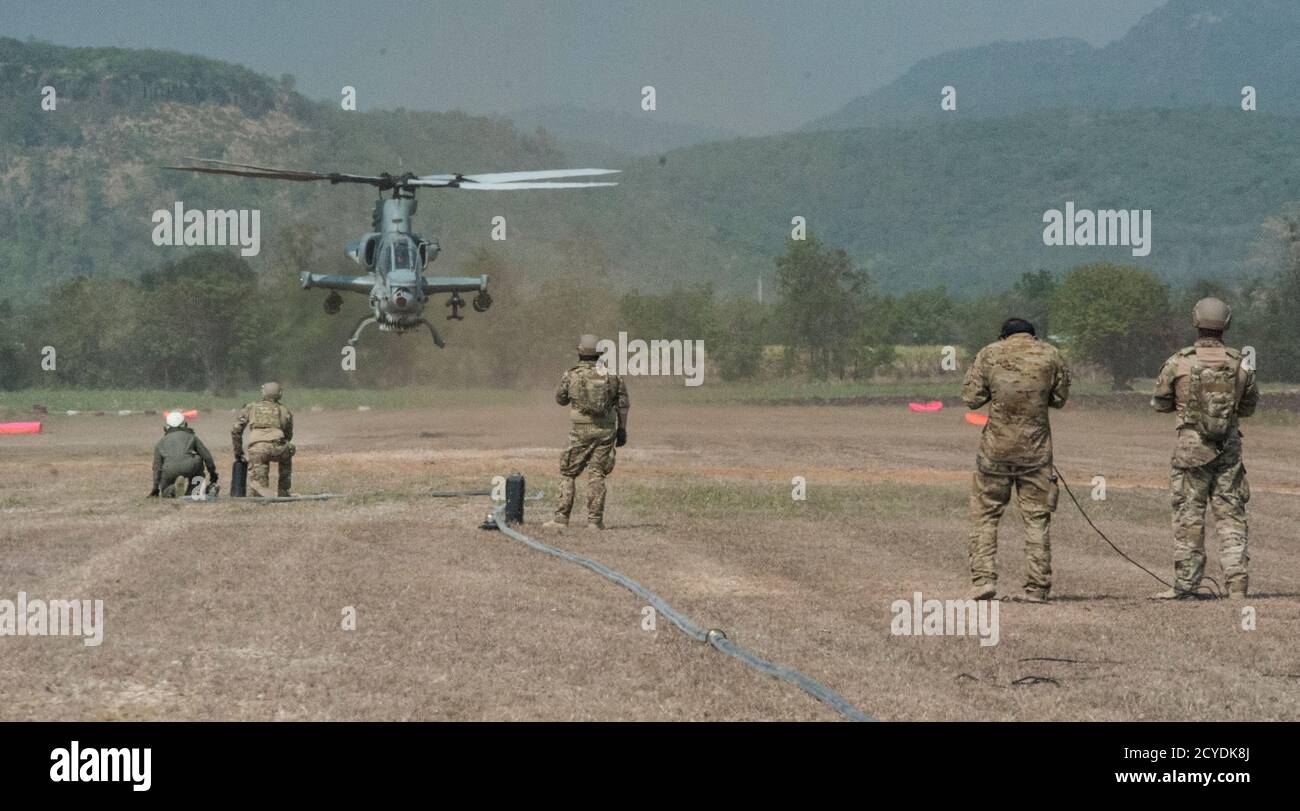 La Fuerza Aérea de EE.UU. 18 preparación Logística Escuadrón adelante punto de reabastecimiento de combustible (FARP) técnicos y 1ra Operaciones Especiales escuadrón loadmasters se preparan para realizar operaciones de FARP con un cuerpo de Marina de EE.UU. 1 Ala Aviación Marina AH-1 Cobra 14 de febrero de 2018, en Chandy Range, Tailandia. La capacidad de FARP del 353º Grupo de Operaciones Especiales ofrece una opción de repostaje encubierta en situaciones en las que las capacidades de repostaje tradicionales no son factibles. (EE.UU Foto de la Fuerza Aérea por Capt. Jessica Tait) Foto de stock