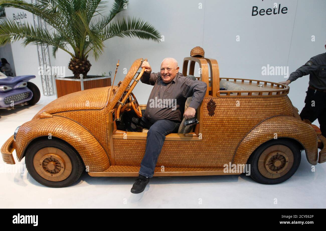 Giorgio Maric of Bosnia and Herzegovina poses in a wooden Volkswagen (VW)  Beetle at the Essen Motor Show in Essen November 30, 2013. Momir Bojic, who  fabricated the car using 20,000 oak