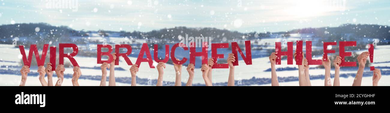 Manos sosteniendo la palabra Wir brauchen Hilfe significa que necesitamos ayuda, fondo de invierno Foto de stock