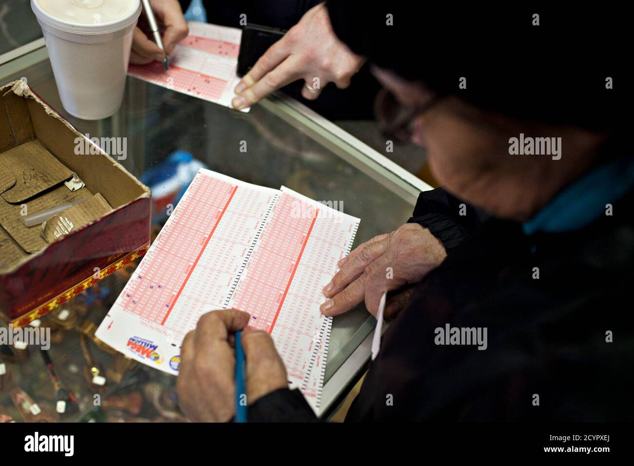Una mujer llena un boleto de lotería Mega Millions en una tienda de tabaco  en Broadway, en Nueva York, 30 de marzo de 2012. El premio mayor de Mega  Millions había crecido