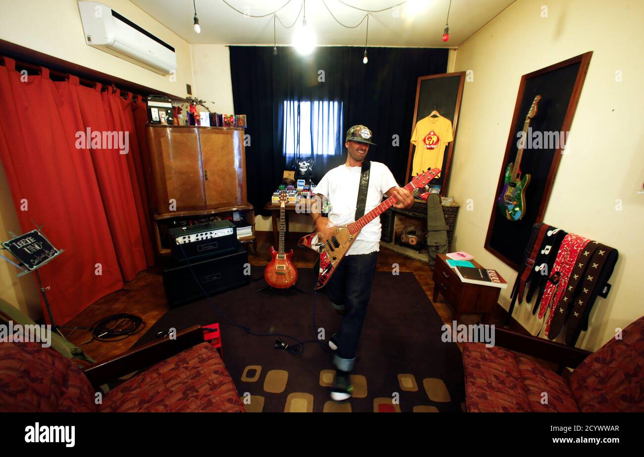 Musician and former skate pro Gianfranco De Gennaro plays a skate guitar  made by his associate Argentine luthier Ezequiel Galasso at their studio in Buenos  Aires October 17, 2014. Working a pedal-powered