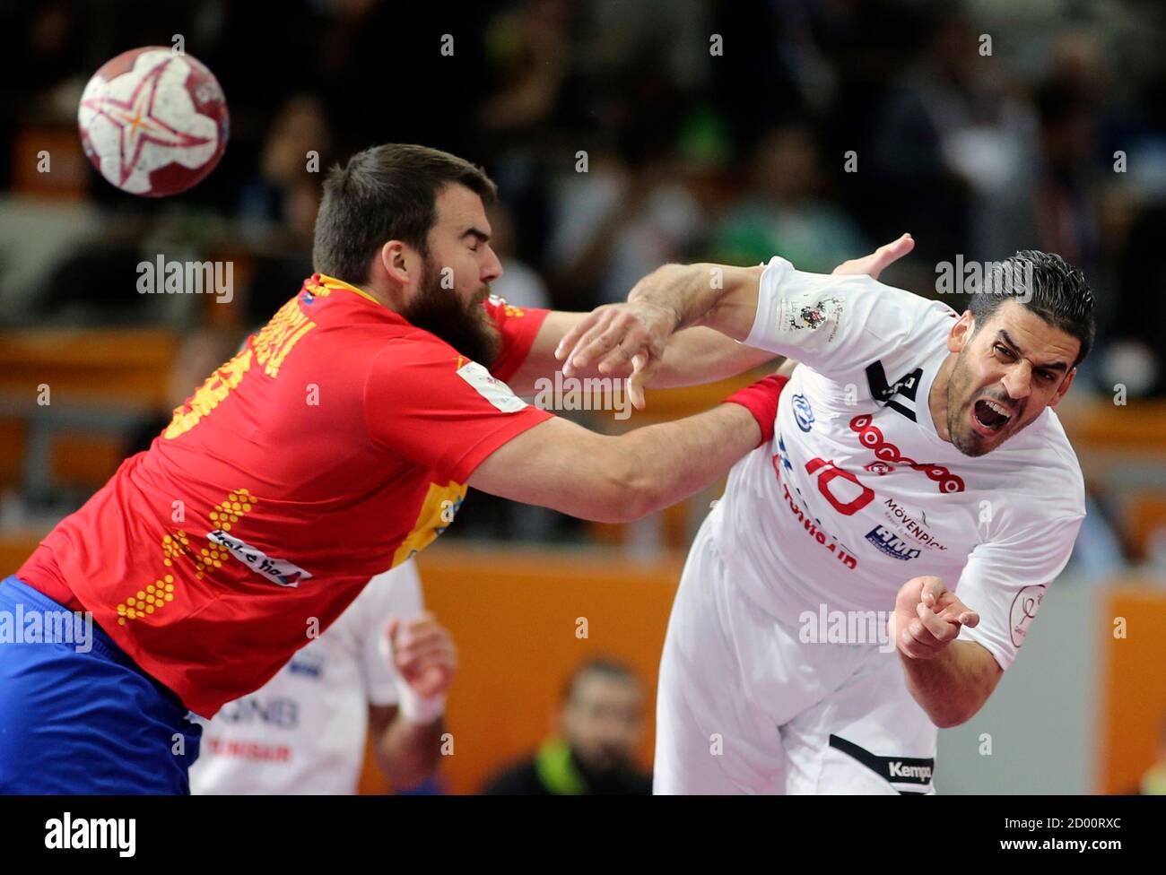 Kamel Alouini de Túnez (R) intenta anotar a Juan Andreu de España durante  la ronda de 16 del 24º Campeonato Mundial de balonmano de hombres en Doha  el 25 de enero de