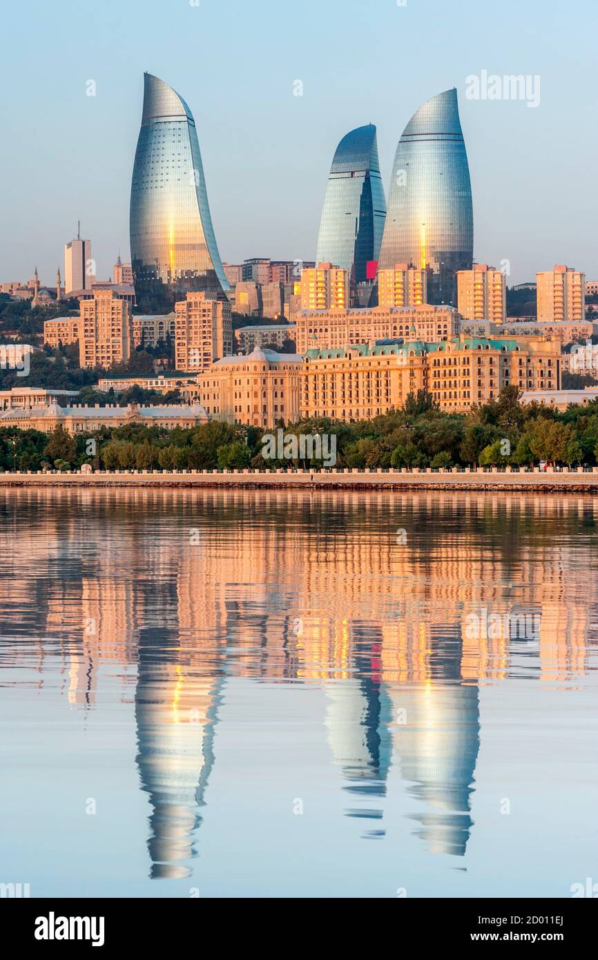 Torres de la llama se refleja en las aguas de la Bahía de Bakú al amanecer. Foto de stock