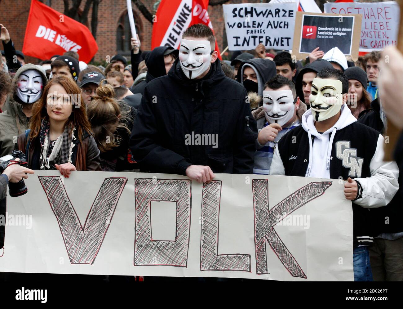 Protestors wearing Guy Fawkes masks participate in a demonstration against the Anti-Counterfeiting Trade Agreement (ACTA) in Berlin February 25, 2012. Protesters fear that ACTA, which aims to cut trademark theft and other online piracy, will curtail freedom of expression, curb their freedom to download movies and music for free and encourage Internet surveillance. The banner reads "People". REUTERS/Tobias Schwarz (GERMANY - Tags: POLITICS CIVIL UNREST) Foto de stock