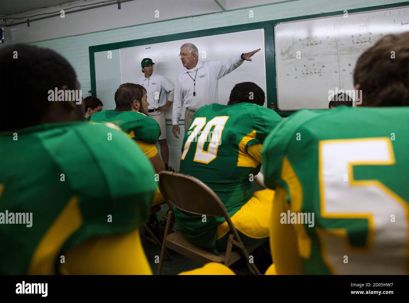 Summerville High School athletic director and head football coach John  McKissick (C) talks to players and staff in the locker room during  half-time of a playoff game at Memorial Stadium in Summerville,
