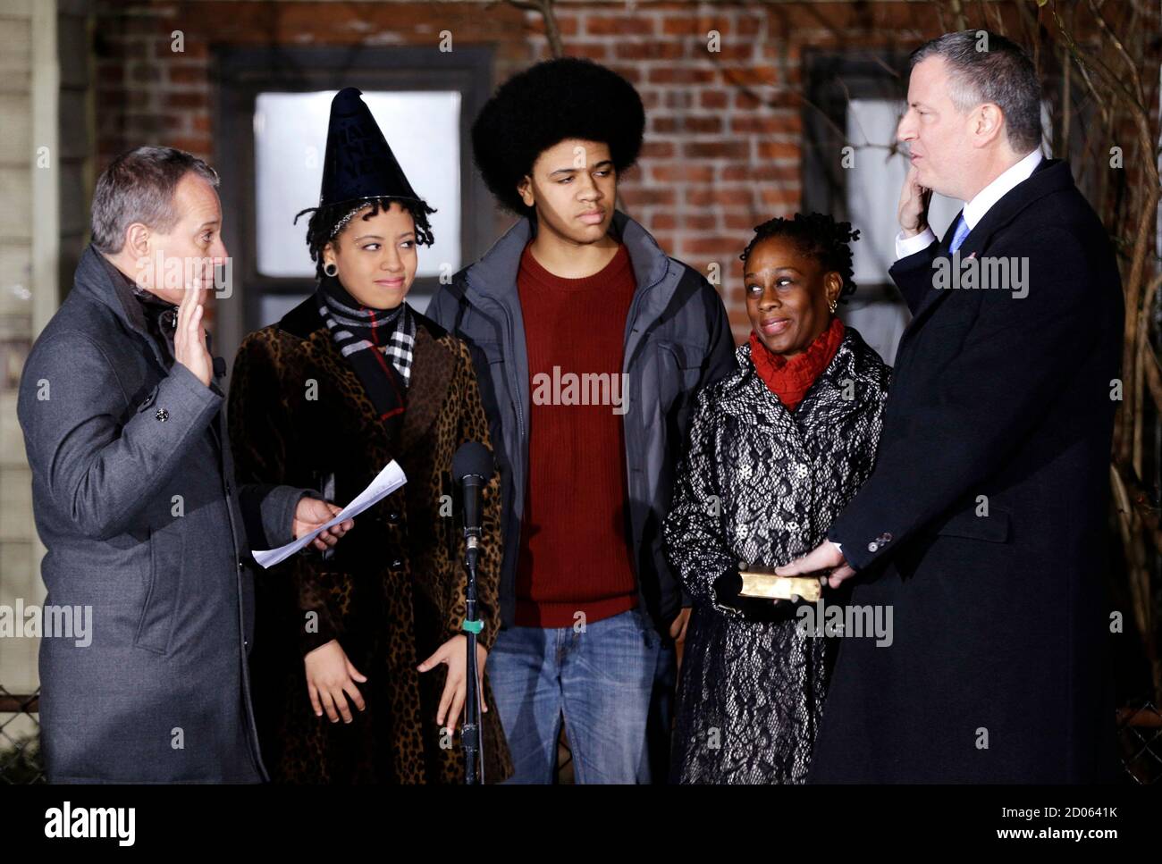 New York City Mayor-elect Bill de Blasio (R) is sworn in as the mayor of  New York City by State Attorney General Eric Schneiderman (L) while his  children Chiara (2nd L), Dante (