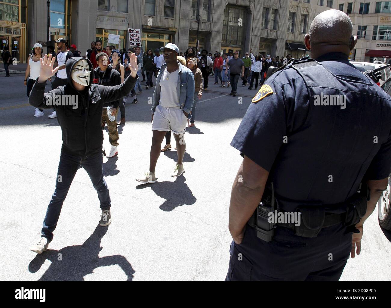 Un manifestante con las manos arriba camina por un oficial de policía de  Cleveland después de un veredicto no culpable para el oficial de policía de  Cleveland Michael Barlo por cargos de