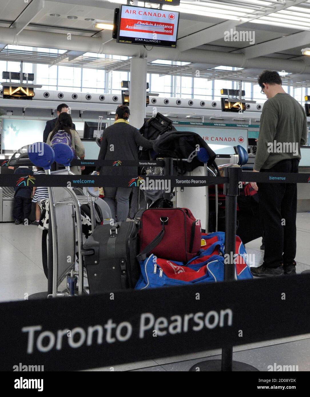 Los pasajeros de Air Canada se alinean en el mostrador de facturación de  equipajes del Aeropuerto Internacional Pearson en Toronto el 13 de abril de  2012. Air Canada canceló al menos 30