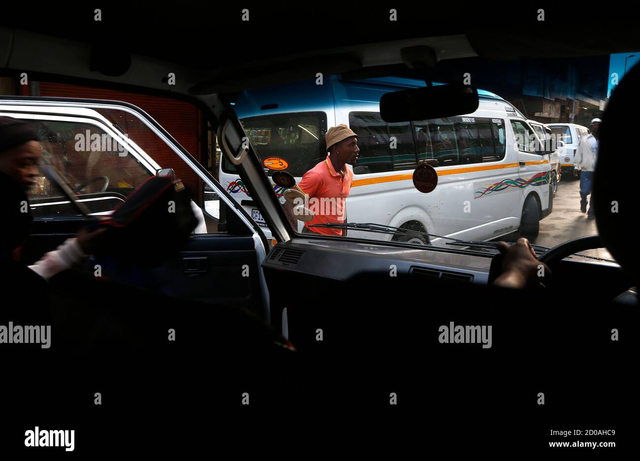 Los pasajeros bajan desde un minibús taxi en el centro de Johannesburgo 21 de febrero de 2014. La industria de taxis de Sudáfrica, despreciada por otros automovilistas por conducir con imprudencia y perparada por una reputación de violencia, mueve a 15 millones de personas cada día, la mayoría de ellos negros de bajos ingresos. Más como los autobuses que los taxis de Nueva York o Londres, los rumiantes 16-navegantes son las ruedas de la economía más grande de África. Foto tomada en febrero de 21. Para combinar la historia DE SUDÁFRICA-TAXIS/ REUTERS/Mike Hutchings (SUDÁFRICA - Tags: TRABAJO DE NEGOCIOS DE TRANSPORTE) Foto de stock