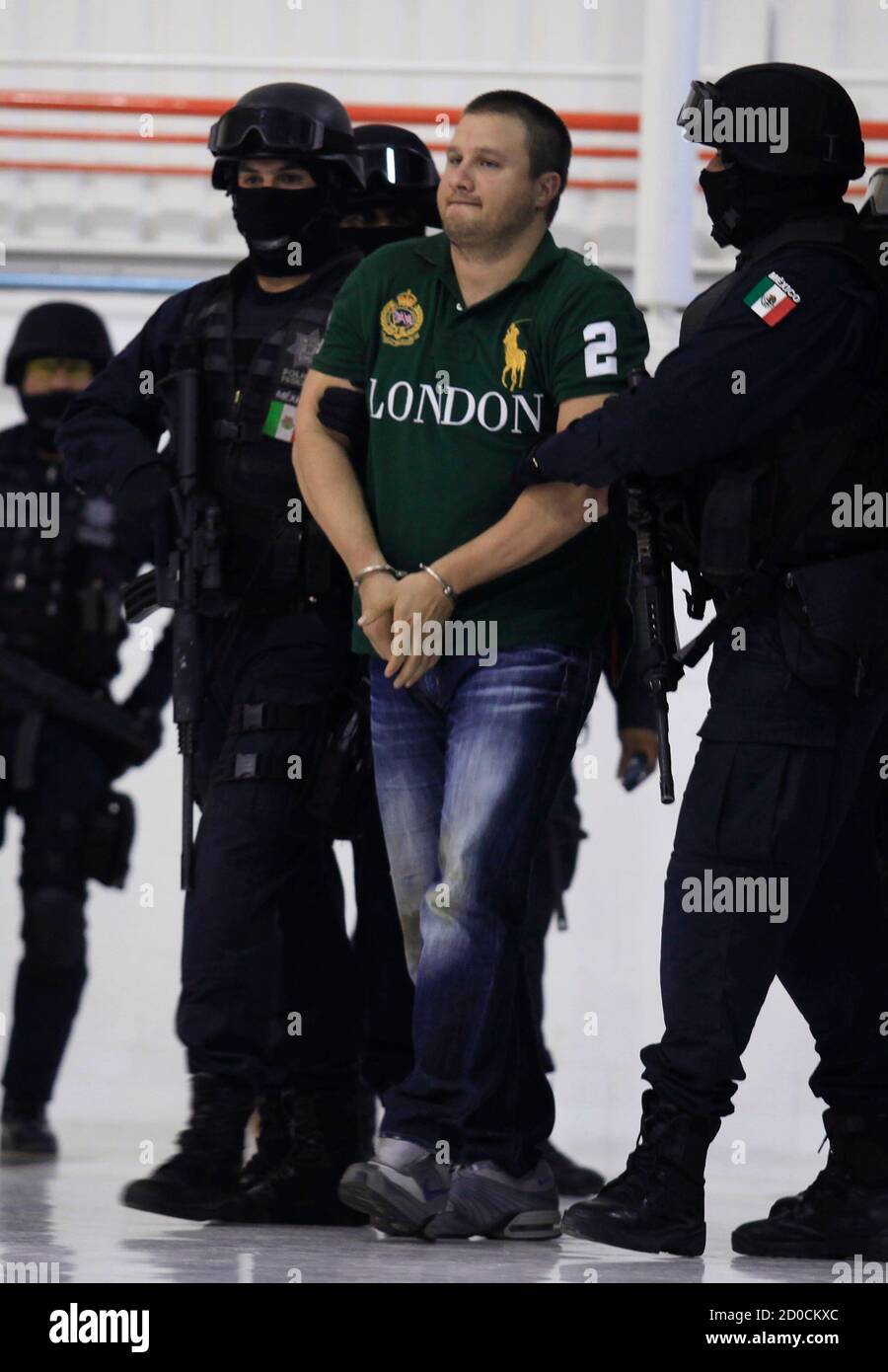 Major drug trafficker Edgar "La Barbie" Valdez is escorted by Mexican  federal police during a news conference at the federal police center in  Mexico City August 31, 2010. Mexico captured Valdez on