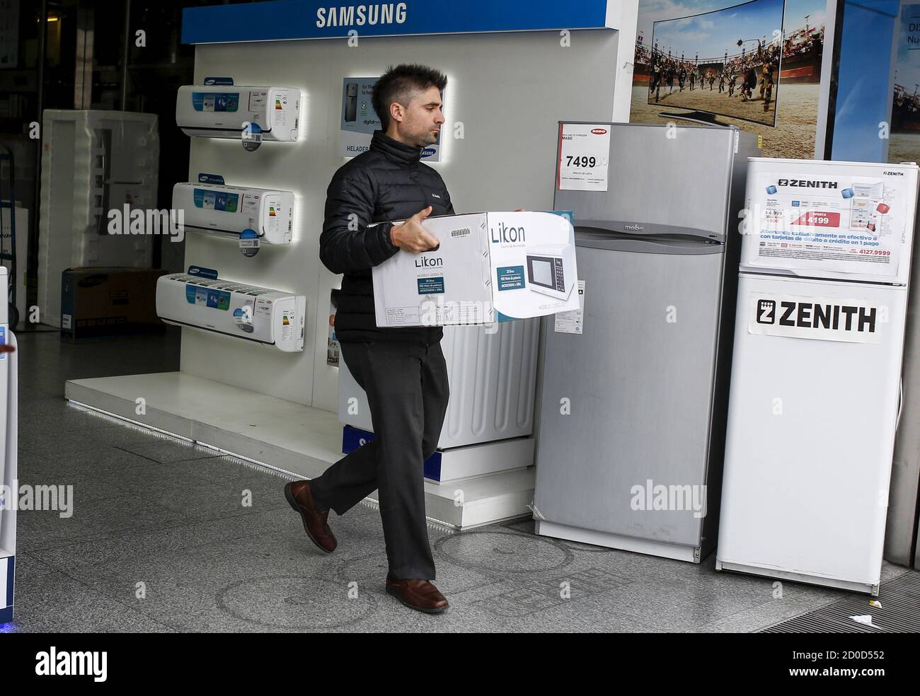 Un cliente lleva un horno microondas que compró en una tienda de  electrodomésticos en Buenos Aires, 22 de junio de 2015. Justo el año  pasado, Argentina se enfrentaba a la recesión, la