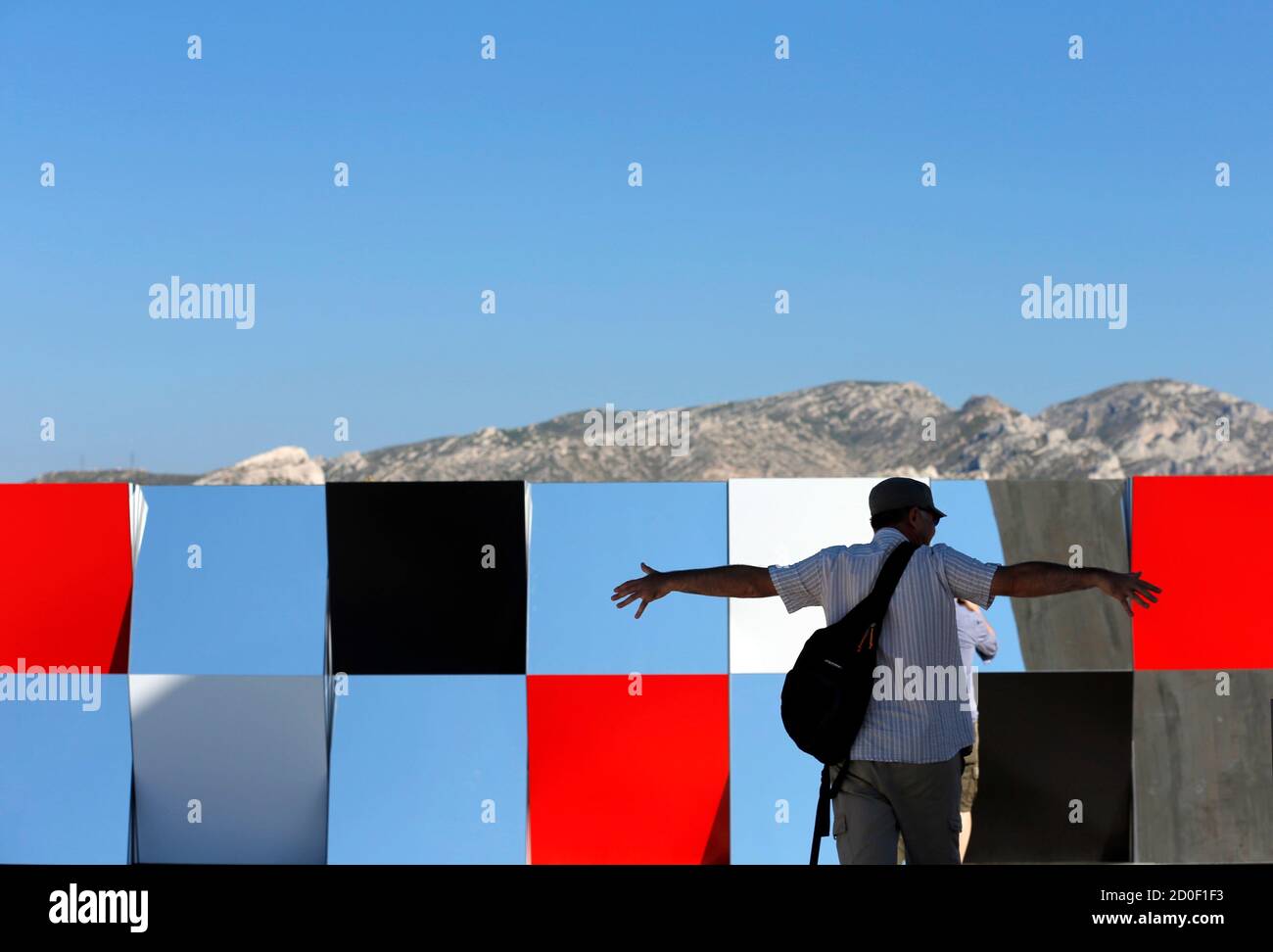 A visitor gestures as he walks past a creation as part of the exhibition "Defini Fini Infini, Travaux in situ" by French artist Daniel Buren at the MaMo art center in Marseille September 12, 2014. The MaMo contemporary art center is installed on the restored rooftop terrace of Le Corbusier's 1947 Cite Radieuse (Radiant City) and created by French designer Ora-Ito. The exhibition will run until September 30, 2014. REUTERS/Jean-Paul Pelissier (FRANCE - Tags: ENTERTAINMENT SOCIETY) Foto de stock