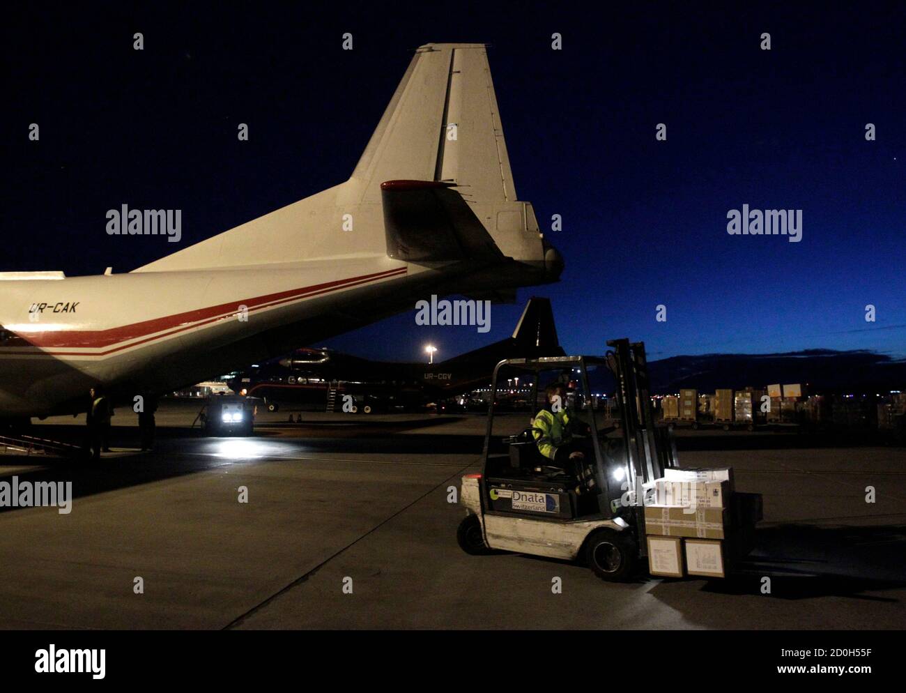 El personal de tierra carga suministros de ayuda médica para Libia en un avión Antonov 12 en el aeropuerto de Cointrin en Ginebra el 25 de febrero de 2011. El Comité Internacional de la Cruz Roja (CICR) está enviando 16 toneladas de suministros médicos a Libia divididos en dos aviones, uno de ellos a Egipto y el otro a Túnez. REUTERS/Denis Balibouse (SUIZA - Tags: POLÍTICA) Foto de stock