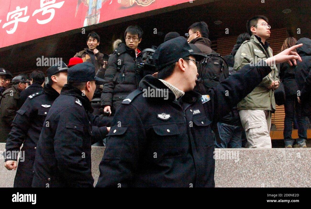 Policemen shout at a crowd that gathered outside a Mcdonald's restaurant  after internet social networks called for a "Jasmine Revolution" protest in  central Beijing February 20, 2011. Chinese President Hu Jintao called