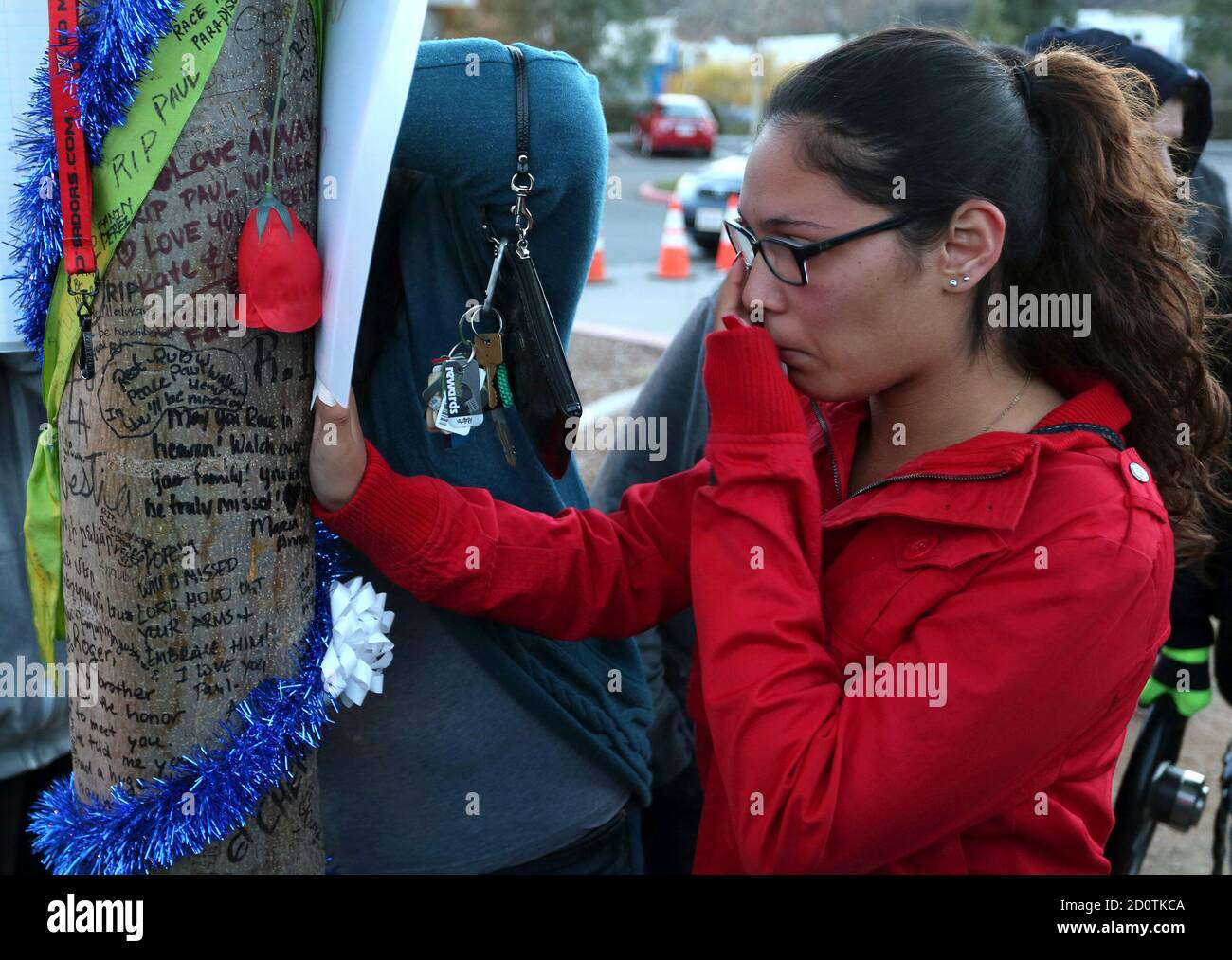 Krysha Converse wipes a tear reading notes written on a tree during an  unofficial memorial event for "Fast and Furious" star Paul Walker in Santa  Clarita, California December 8, 2013. Thousands of