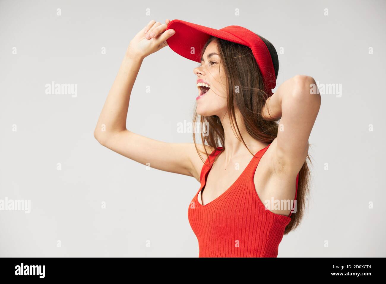 mujer alegre con boca abierta mirando a la tapa lateral camiseta roja en la  cabeza Fotografía de stock - Alamy
