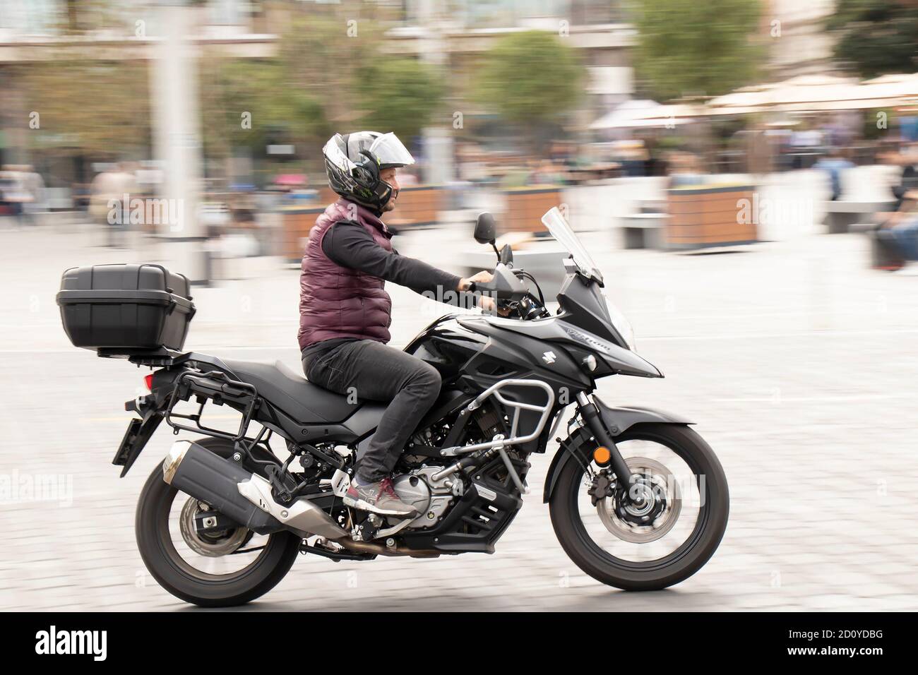Belgrado, Serbia - 02 de octubre de 2020: Hombre montando una moto rápida con la caja trasera en calle vacía por plaza de la ciudad, barrido de tiro Foto de stock