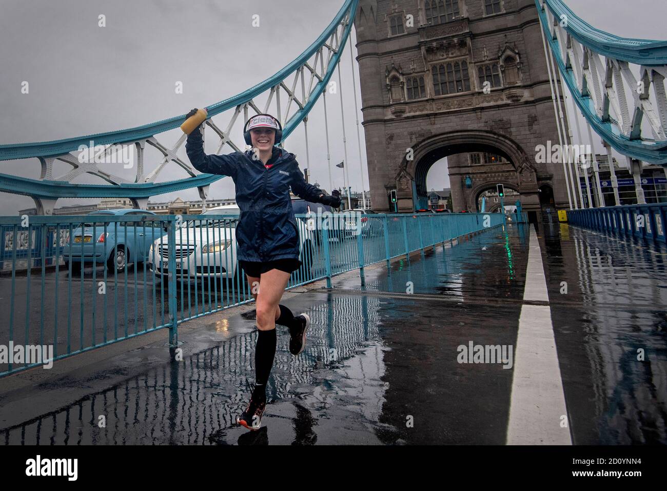 Un corredor que lleva un número de carrera de la Maratón de Londres cruza Tower Bridge mientras unas 45,000 personas están corriendo o caminando la 40ª Maratón de Londres a lo largo de su propia ruta de 26.2 millas alrededor del Reino Unido, después de que el evento originalmente planeado para abril de 26 fue pospuesto debido al coronavirus. Foto de stock