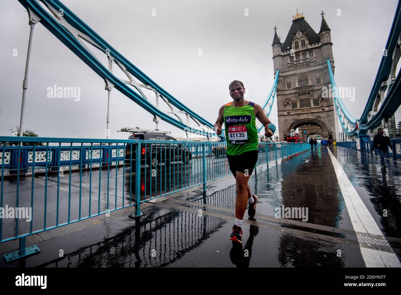 Un corredor que lleva un número de carrera de la Maratón de Londres cruza  Tower Bridge mientras unas 45,000 personas están corriendo o caminando la  40ª Maratón de Londres a lo largo