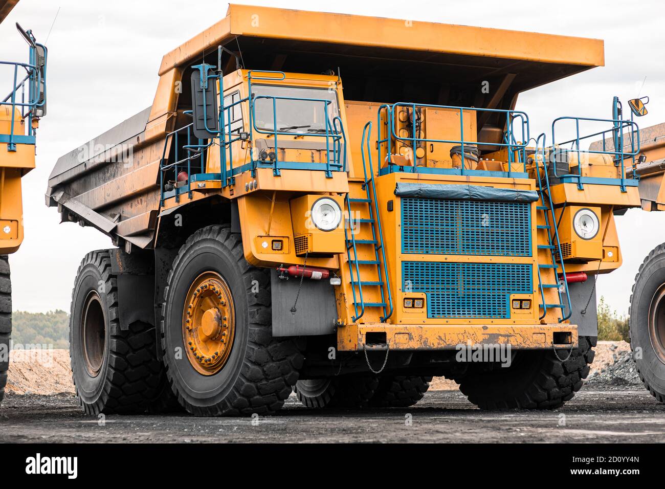 Gran camión volquete de cantera. Gran camión de minería amarillo en el  lugar de trabajo. Carga de carbón en el camión de la carrocería. Producción  de minerales útiles. Maquinaria minera para camiones
