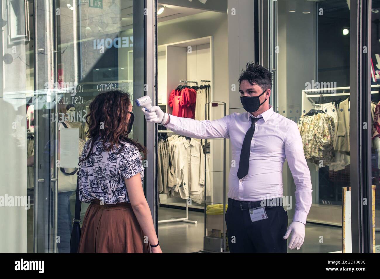 Bolonia: empleado de seguridad comprueba la temperatura de un cliente antes de entrar en la tienda de ropa (Covid-19 2020 pandemia Fotografía stock - Alamy