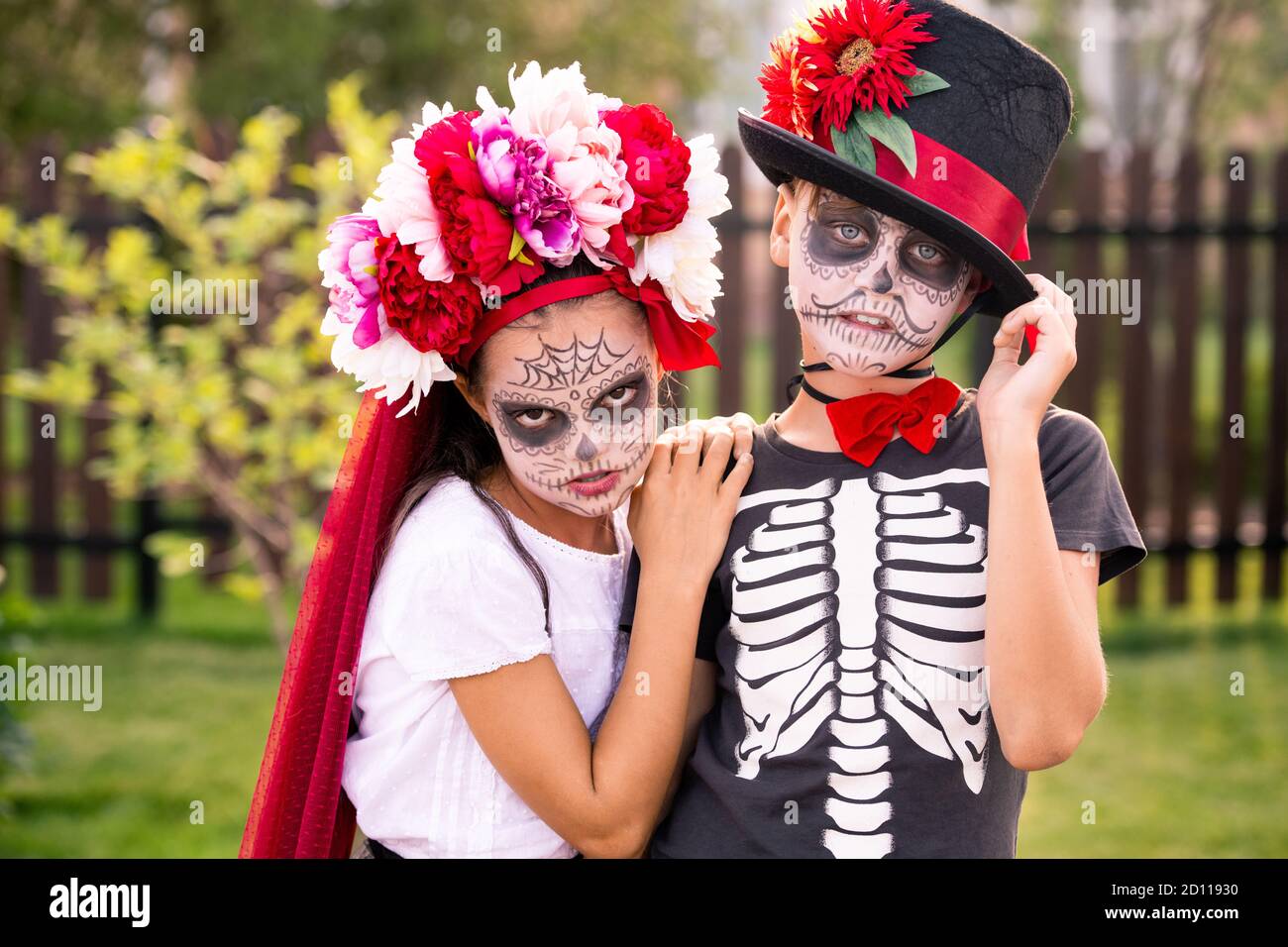 Niño y niña sombría con caras pintadas en trajes de Halloween mirarte  Fotografía de stock - Alamy
