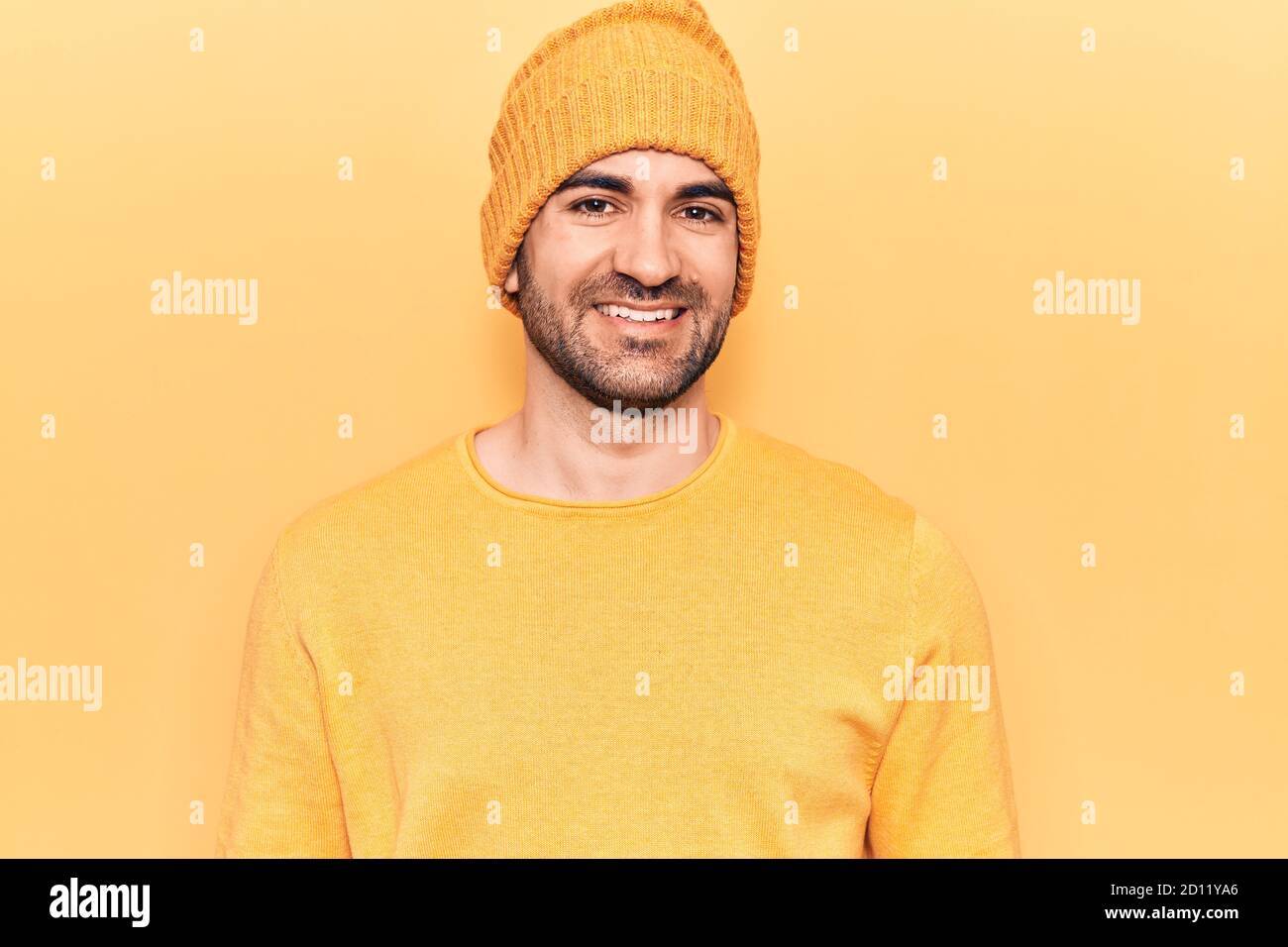 Joven hombre calvo guapo con suéter y gorro de lana con una sonrisa feliz y  fresca en la cara Fotografía de stock - Alamy