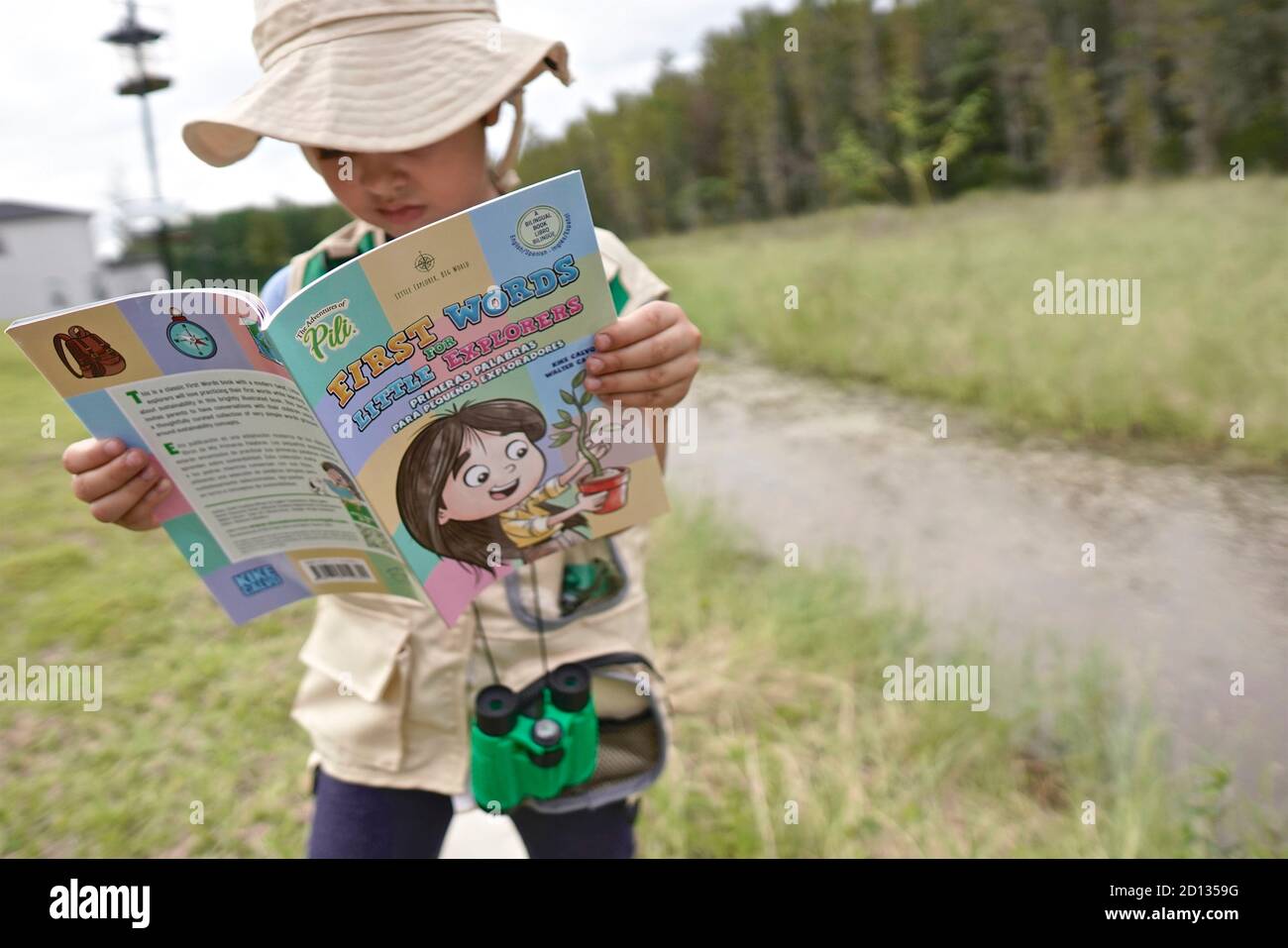 Niña aprendiendo sobre la naturaleza en una clase al aire libre. Foto de stock