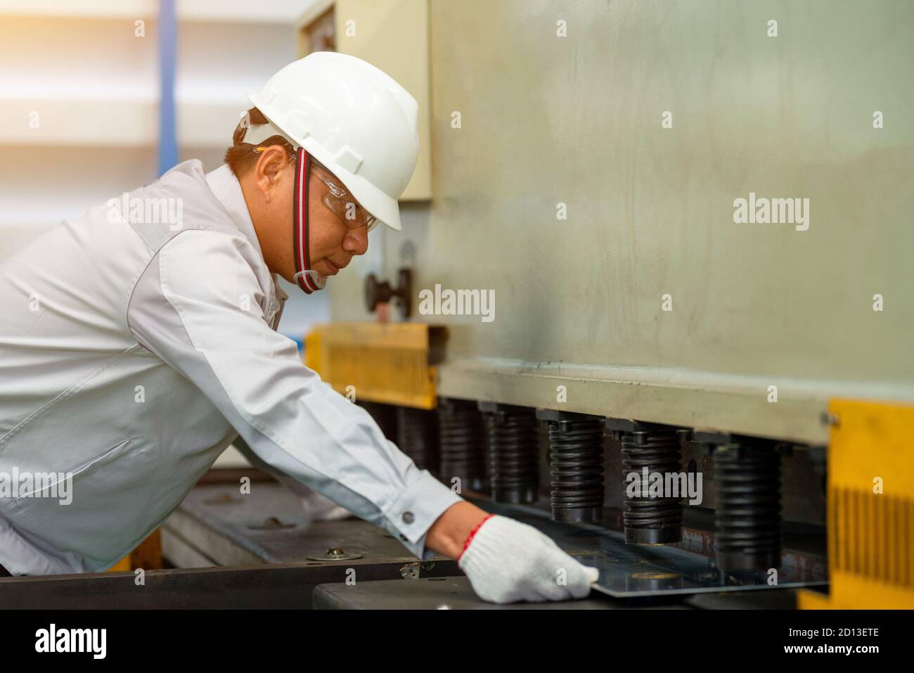 Los trabajadores hacen la flexión de la chapa metálica por el freno de la prensa hidráulica en la fábrica. Foto de stock