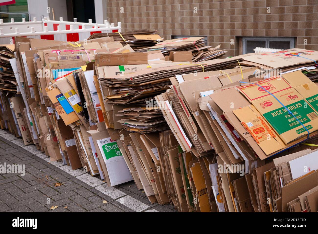 Cajas de cartón desmontadas y enmarañadas en la acera para su eliminación, Colonia, Alemania. Zerlegte und gebuendelte Pappkartons liegen zum Abtransp Foto de stock