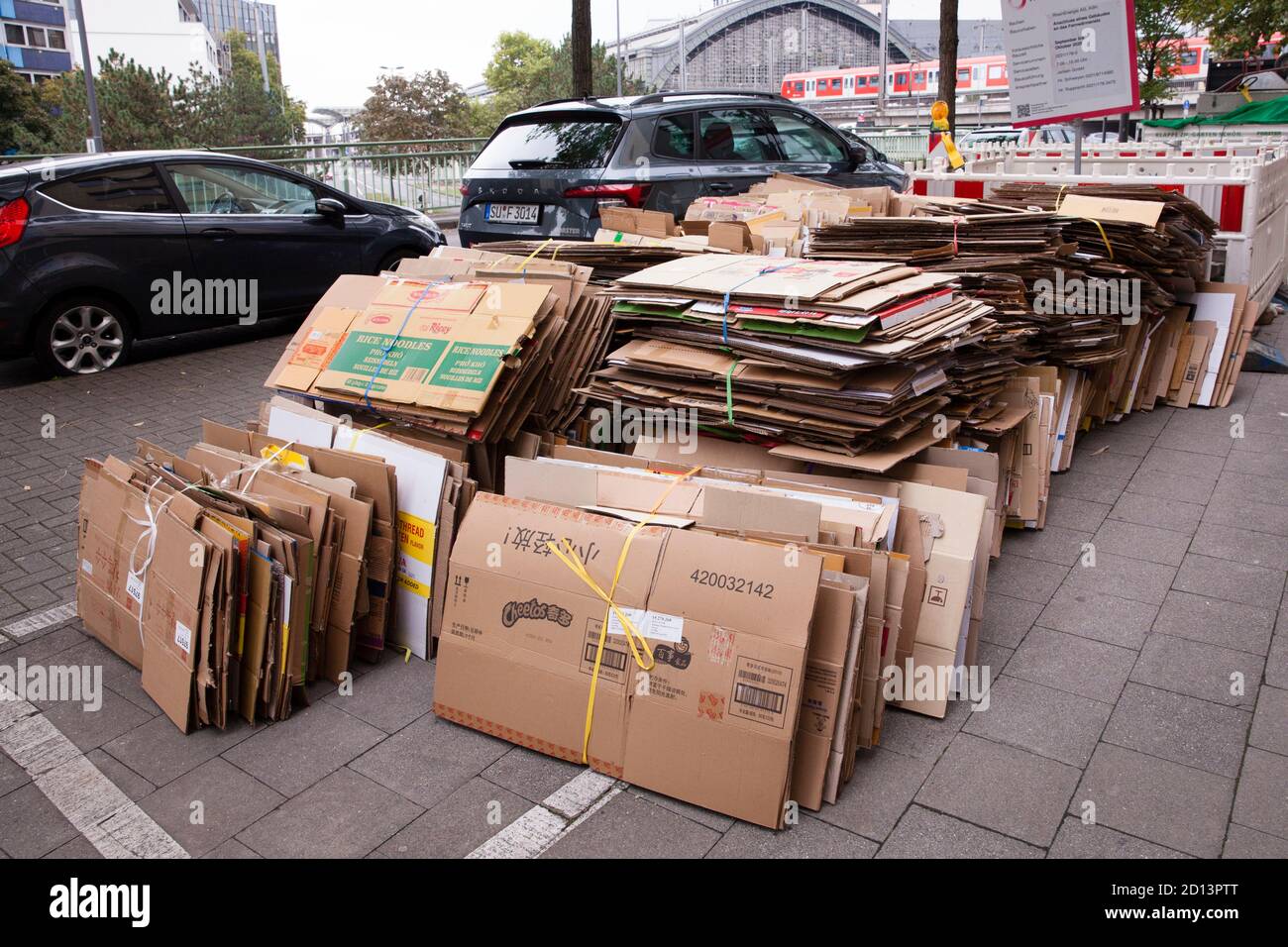 Cajas de cartón desmontadas y enmarañadas en la acera para su eliminación, Colonia, Alemania. Zerlegte und gebuendelte Pappkartons liegen zum Abtransp Foto de stock