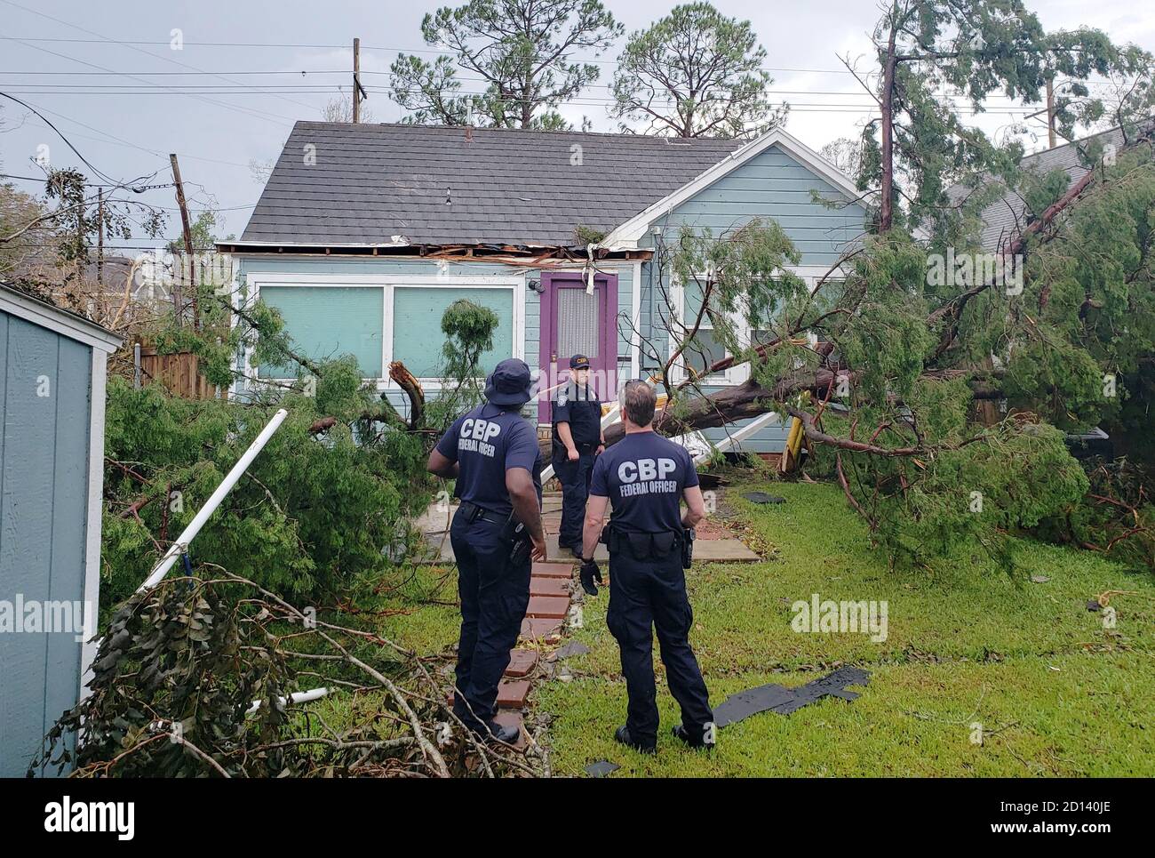Los oficiales del CBP ayudan a proteger una casa en Lake Charles, LA que había sido gravemente dañada por el huracán Laura, que azotó el suroeste de Luisiana el 26 de agosto de 2020. Foto de stock