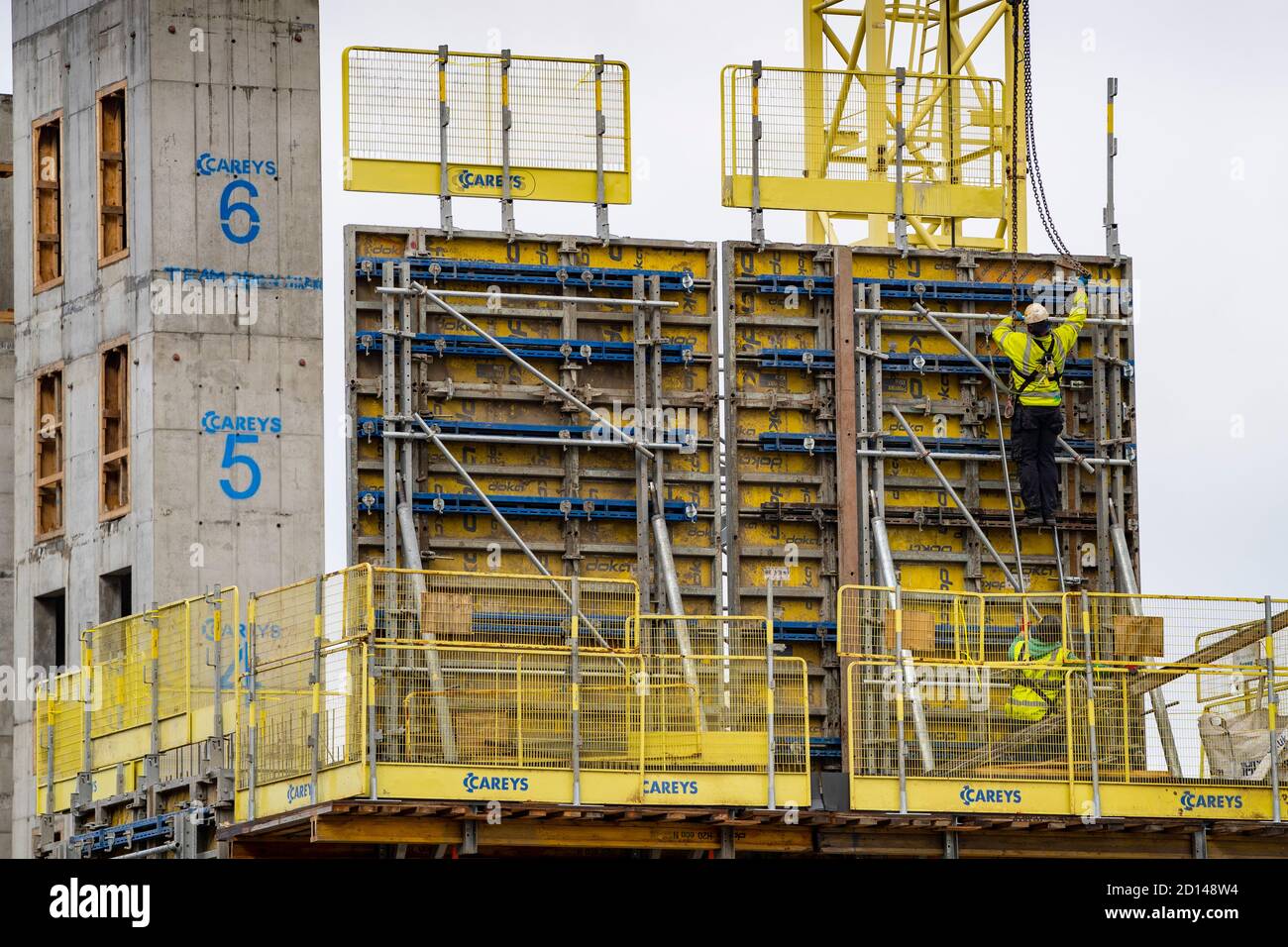 Trabajador de la construcción que se adapta a la formación de una verter de hormigón en el nuevo desarrollo de propiedades de Springside en el pueblo urbano de Moda, Edimburgo, Escocia, Reino Unido Foto de stock
