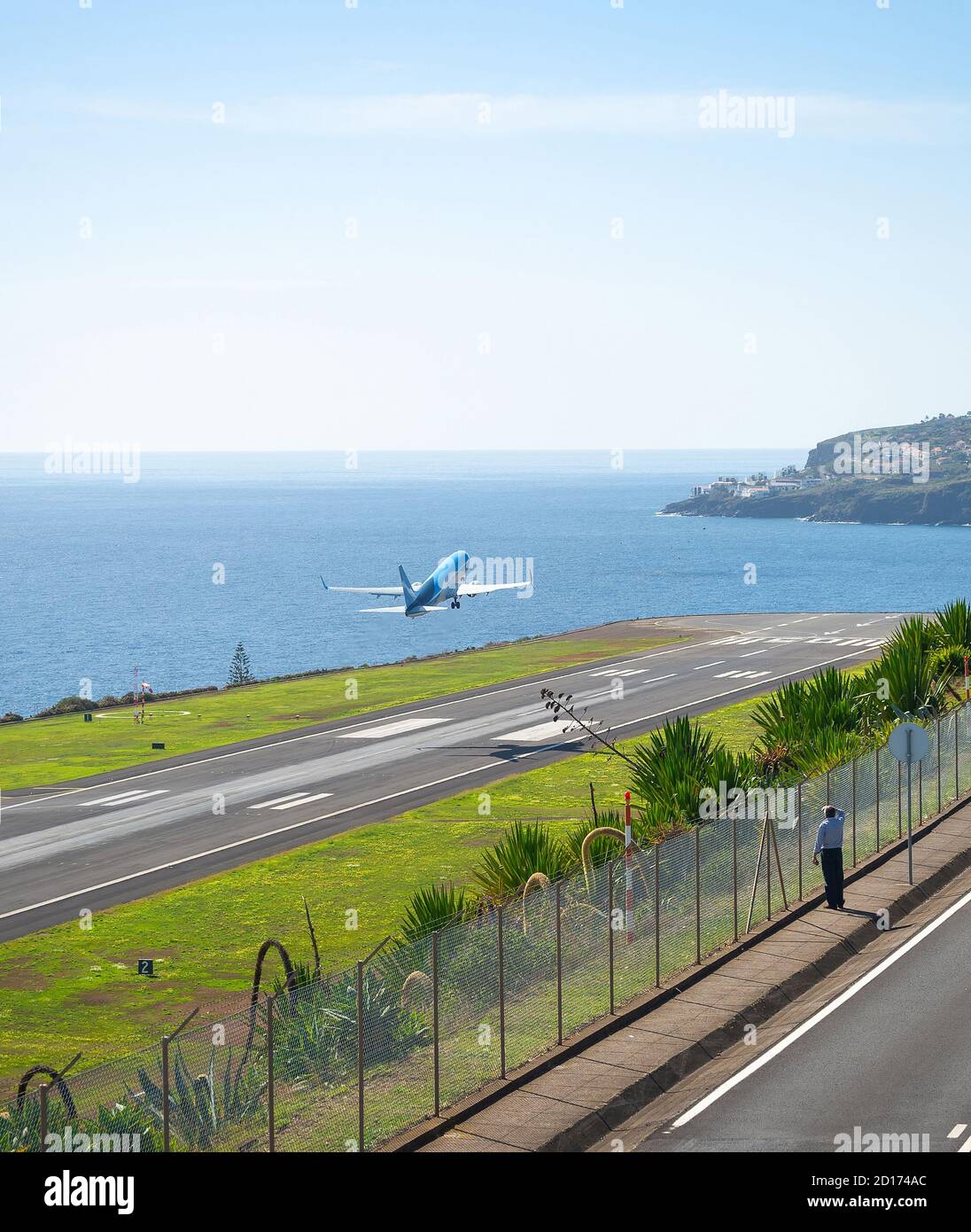 Hombre viendo tomar un avión desde la pista del aeropuerto internacional de Funchal, Madeira, Portugal Foto de stock