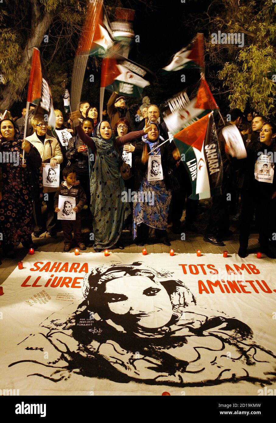 Demonstrators shout slogans and wave flags in front of a picture of Western Sahara independence campaigner Aminatou Haidar during a protest in Valencia December 10, 2009. Haidar started a hunger strike 23 days ago in protest at being expelled from her desert homeland. She has been at Lanzarote airport in the Canary Islands refusing food ever since Moroccan authorities put her back on a plane when she returned home to Laayoune after a trip to New York. Banner reads "free Sahara, everybody with Aminatou". REUTERS/Heino Kalis (SPAIN CONFLICT POLITICS) Foto de stock