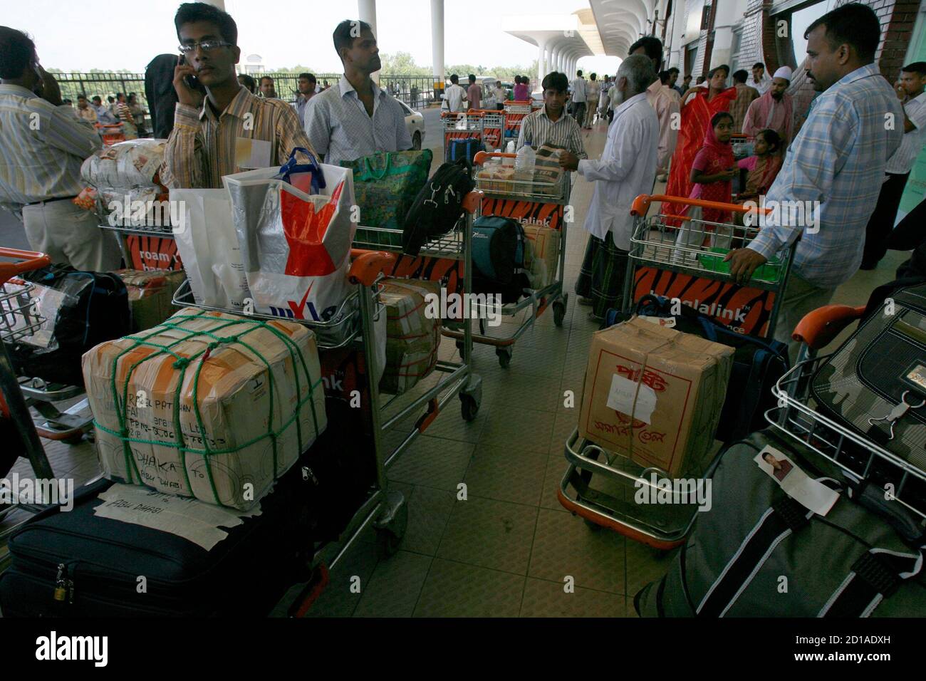 Migrant workers flying to Dubai wait at Zia International airport in Dhaka  June 25, 2008. Migrants ranging from high-paid Western executives to  low-wage Asian labourers have formed the backbone of Dubai development